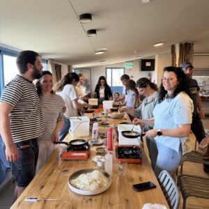 A group of participants at a GVINAGE cheese workshop around a long wooden table
